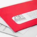 Stack of mail with red envelope on top showing an advertisement inside