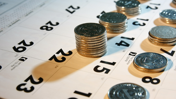 Stacks of quarters sit on top squares of a calendar.