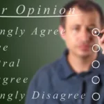 Man stands in front of see-through board with survey questions he is bulleting in front of him