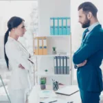 Woman and man staring angrily at each other in an office.