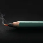 Forest green pencil with smoldering tip against a black background