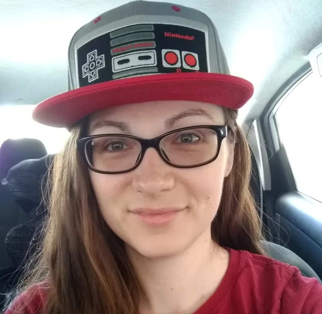 Comprehensive Copywriting Academy student Amy waring a trucker-style hat with a vintage Nintendo controller.