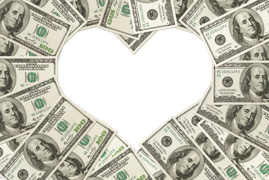 One-hundred-dollar bills are fanned out so the shape forms a white heart in the center.